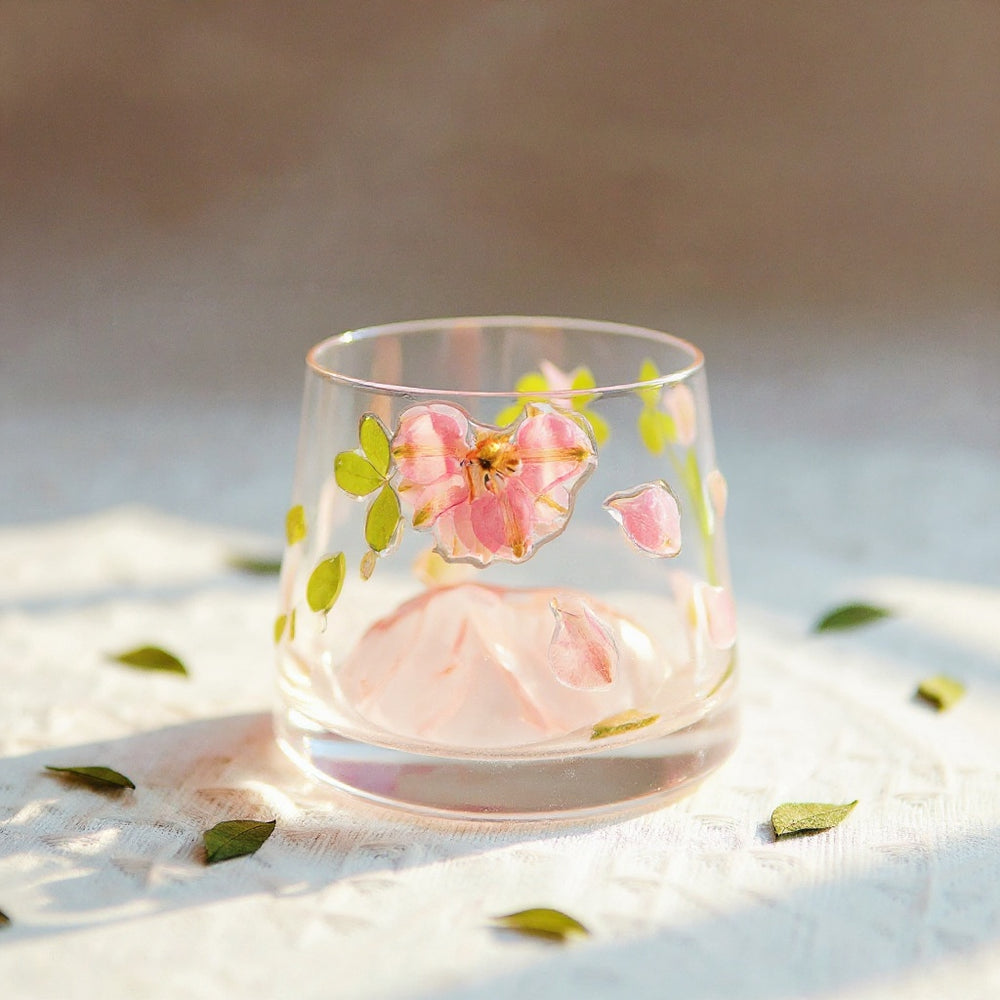 Preserved flower glass tumbler on a neutral background with dried botanicals in soft light.