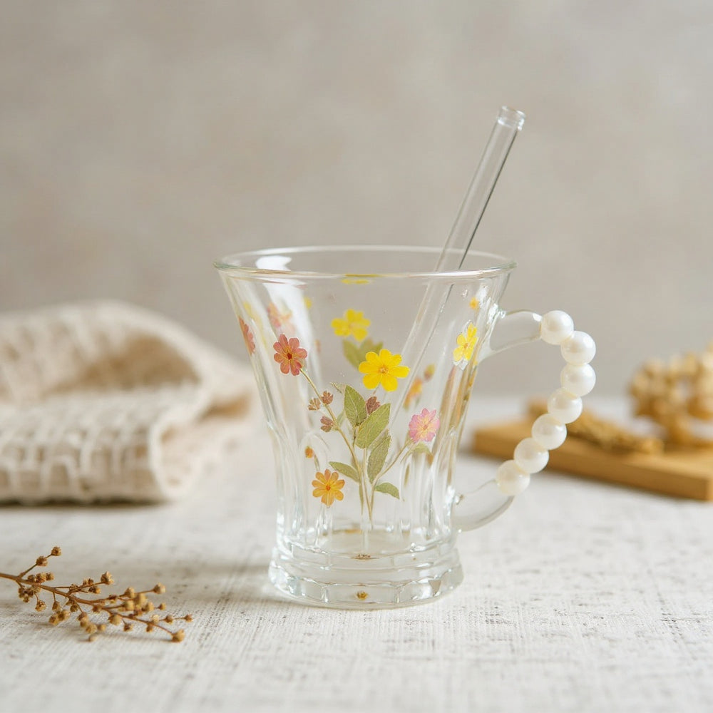 Artisan botanical mug with lid and straw on a neutral surface with natural styling props in soft daylight.