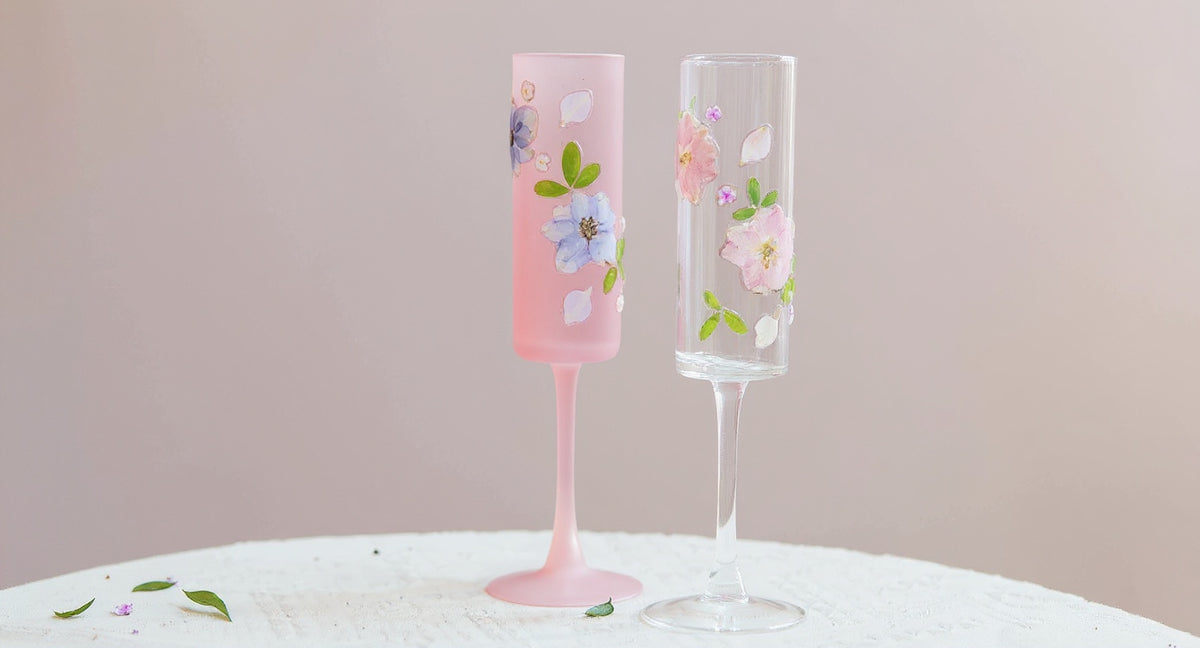 Handmade Frosted Pink Sakura Wine Glass with real dried sakura petals on pink marble surface.