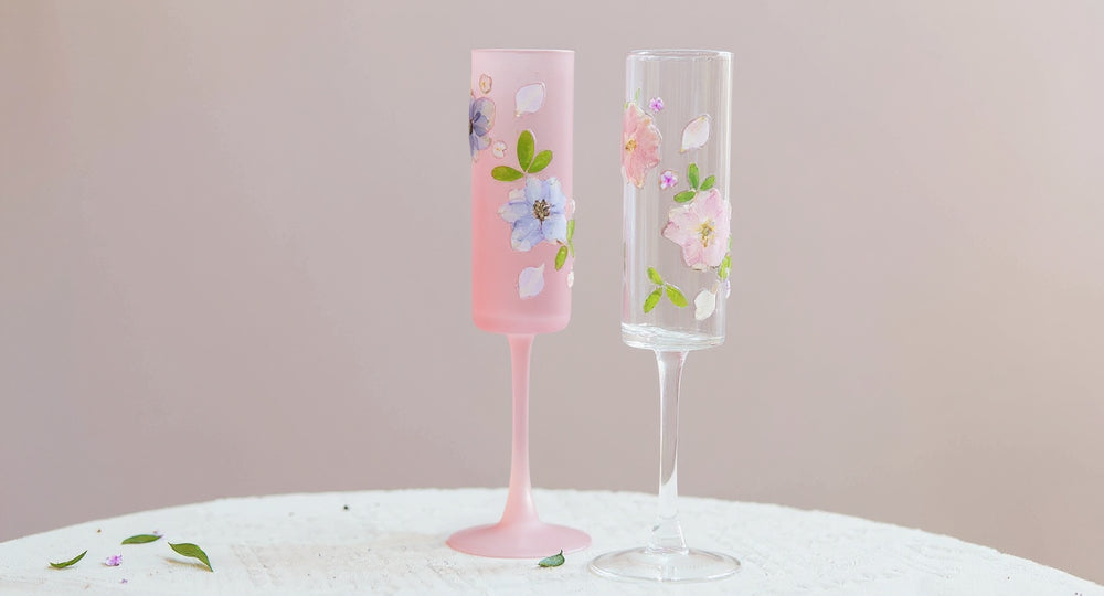 Handmade Frosted Pink Sakura Wine Glass with real dried sakura petals on pink marble surface.