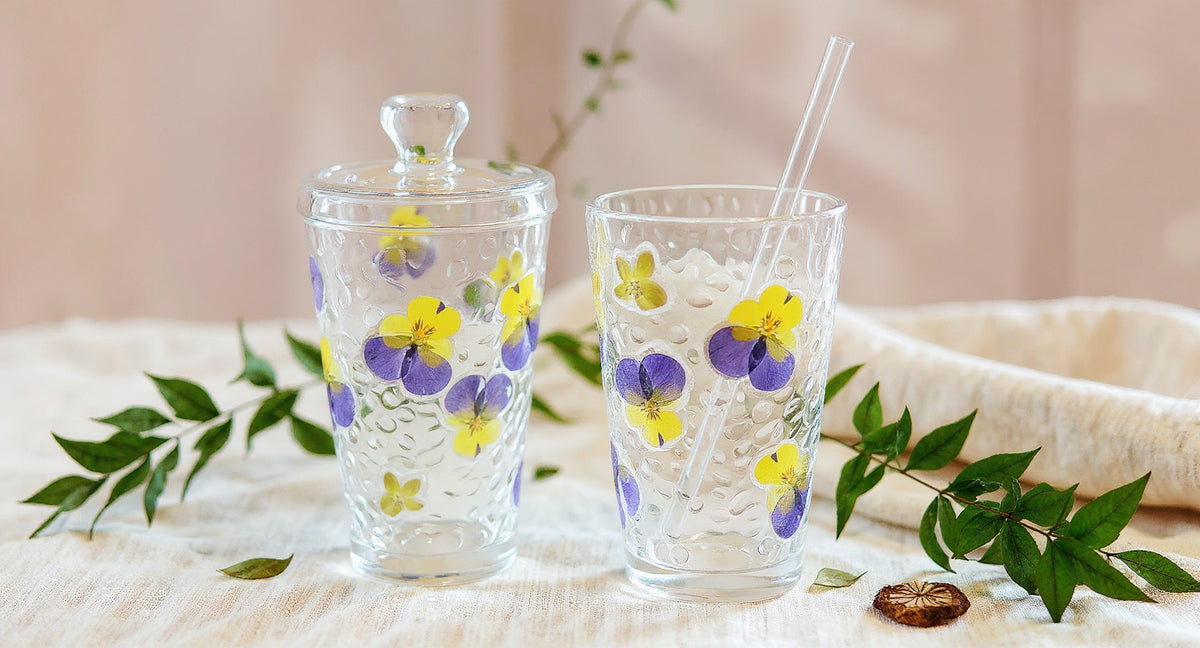 Handmade Pressed Flower Glass Cup Set 400ml with real floral drinkware, lid and straw on linen.