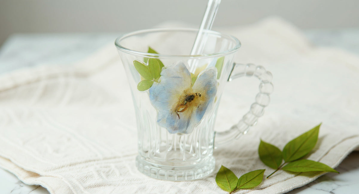 Handmade Real Flower Glass Cup 400ml with beaded handle and glass straw on linen
