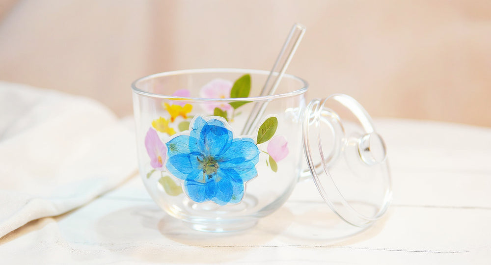Handcrafted Floral Glass Cup with Real Preserved Flowers on white marble table with pampas grass and teaspoon