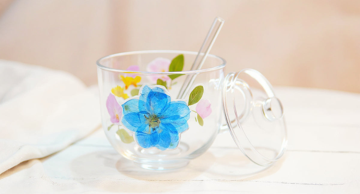 Handcrafted Floral Glass Cup with Real Preserved Flowers on white marble table with pampas grass and teaspoon