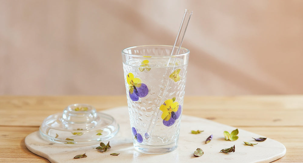 Handmade Real Flower Glass Cup with lid and straw on oak table with dried petals