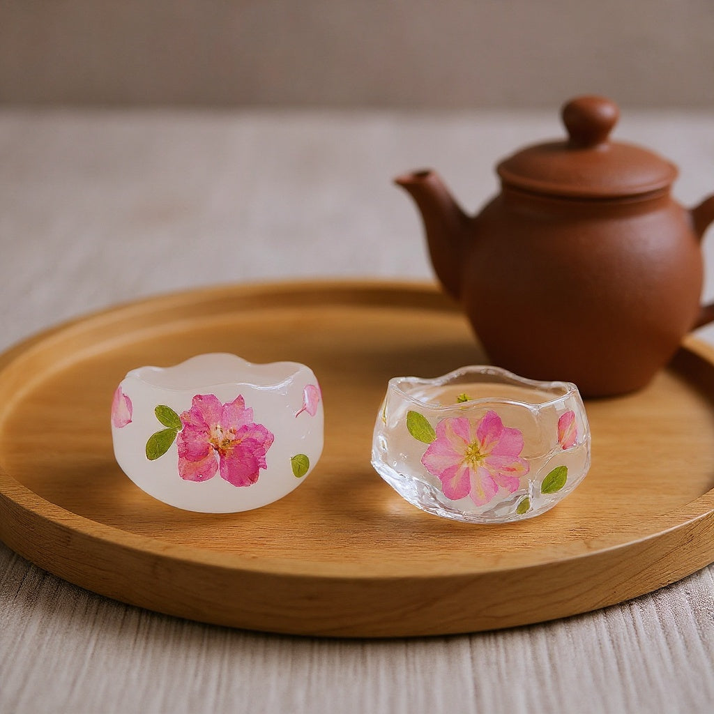 Preserved cherry blossom petal tea cup on a wooden tea tray with a clay teapot, soft natural light, editorial style.