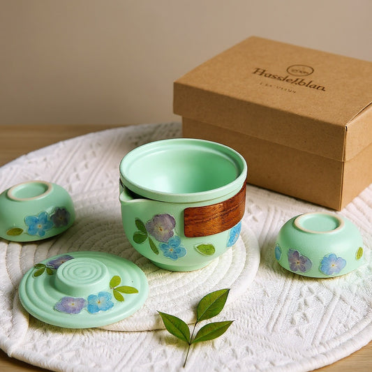 Handmade porcelain gaiwan with embedded dried flowers on a linen background with eco-kraft gift box