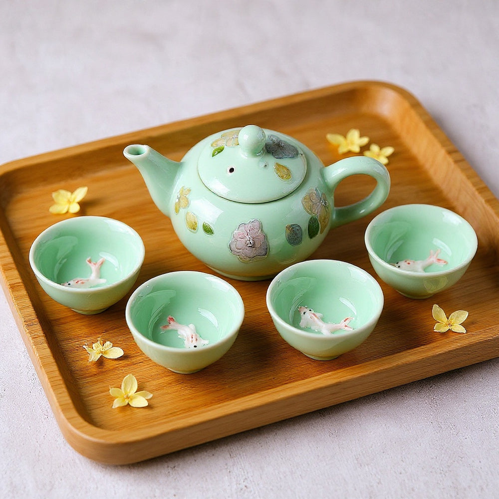 Jade-green celadon tea set with embedded winter jasmine petals and koi fish cups, on a wooden tray, minimalist Zen composition.