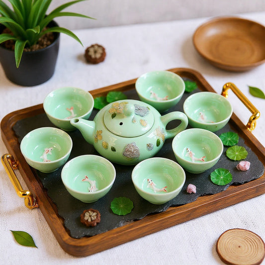 A jade-green celadon tea set with winter jasmine petals and 3D koi fish cups, elegantly displayed on a wooden tray with soft natural light and a minimalist aesthetic.