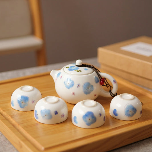 Eco-friendly tea set with preserved blue hydrangea petals on a natural wood surface, soft daylight, Zen styling.