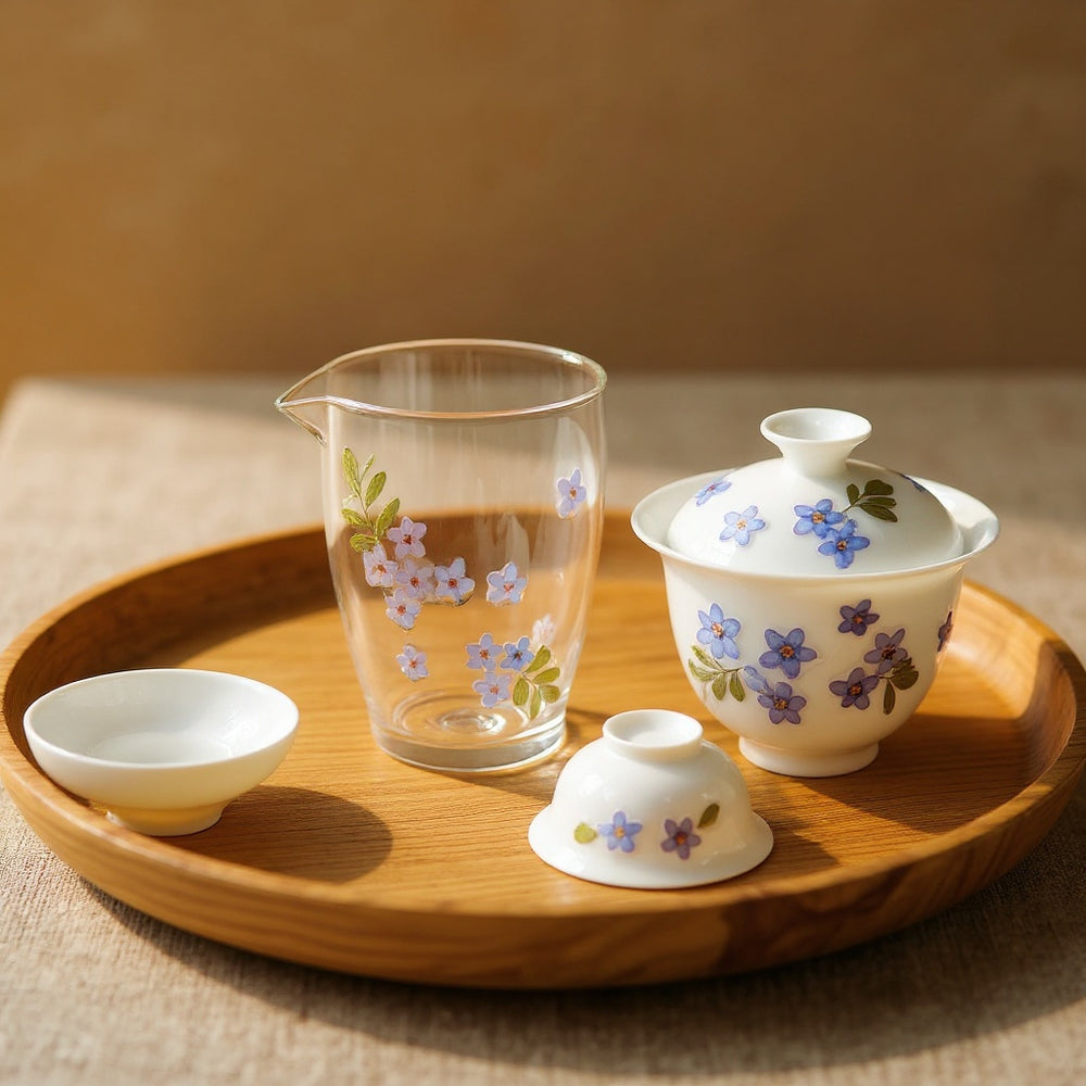 Translucent-white bone china pitcher with cherry blossom petals on wooden tray in soft light.