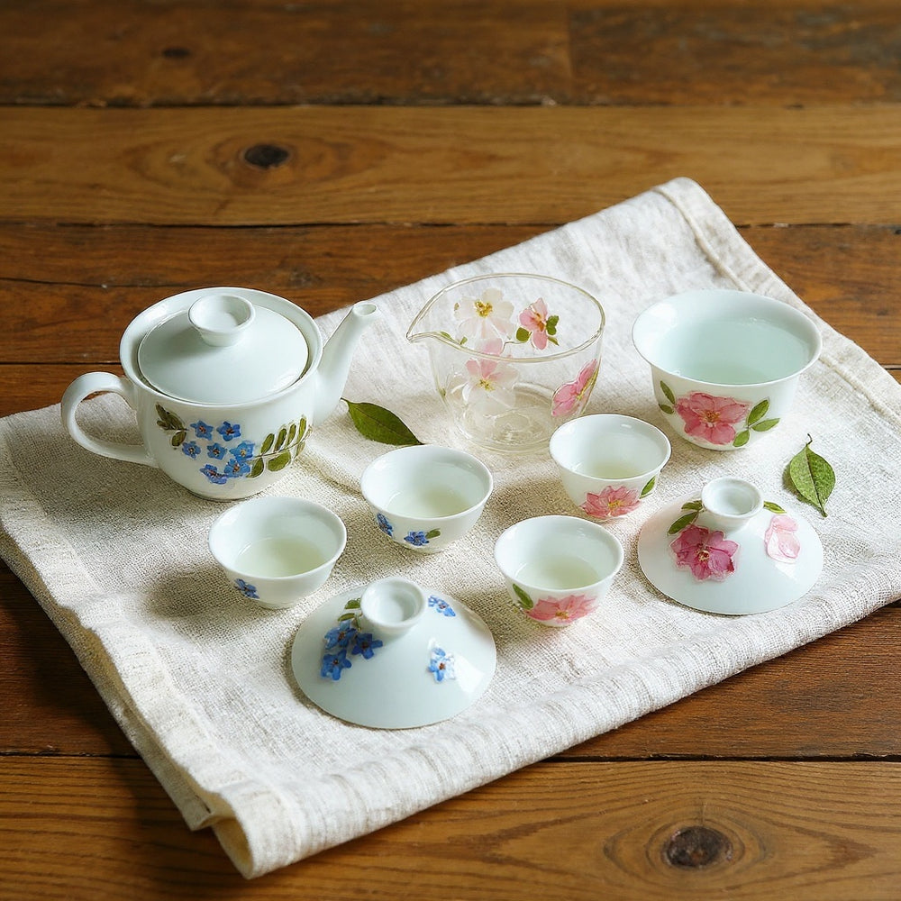 Artisan porcelain gaiwan and teacups with preserved flower petals on aged wood, serene botanical spa aesthetic