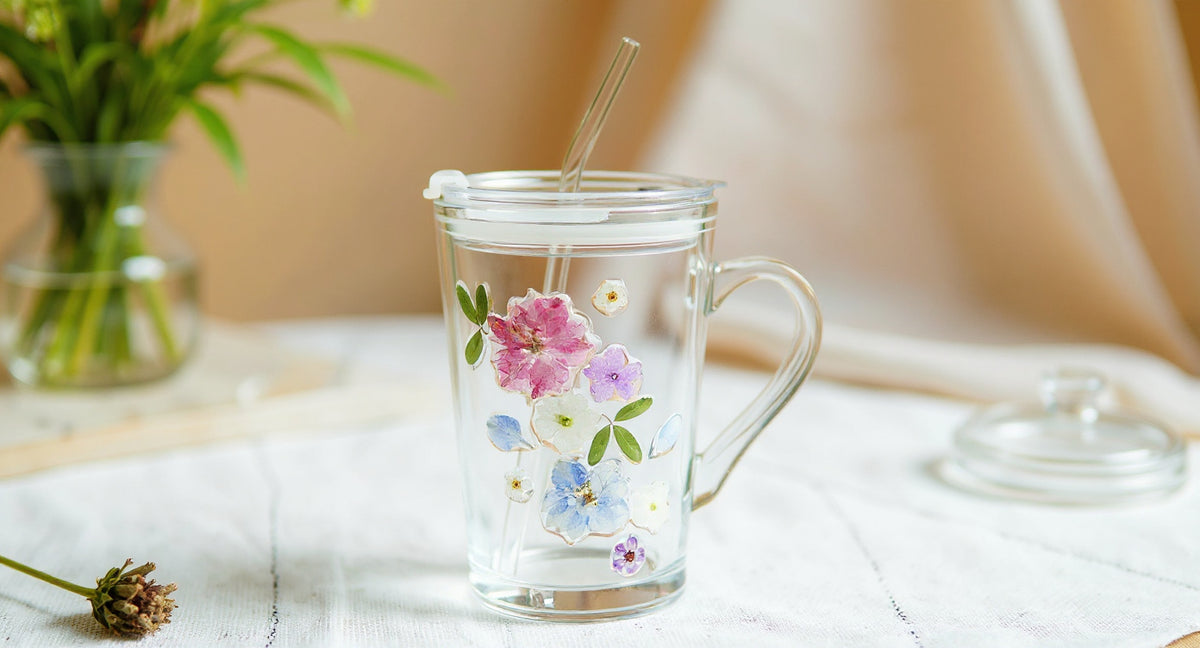 Handmade Pressed Flower Glass Tumbler with real flowers and glass straw on linen.