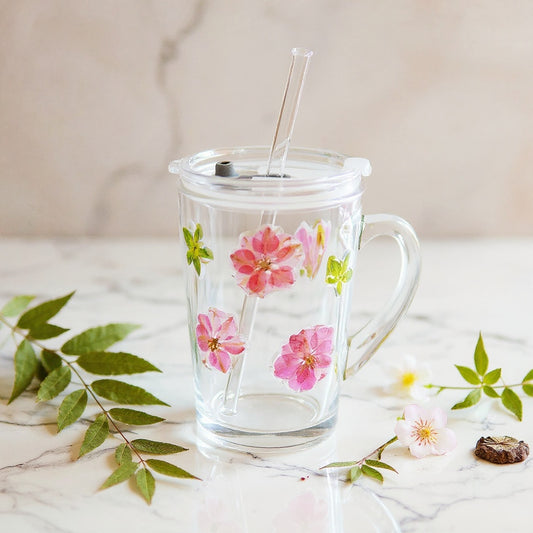 Hero image of eco-friendly glass straw cup with botanical details on marble surface