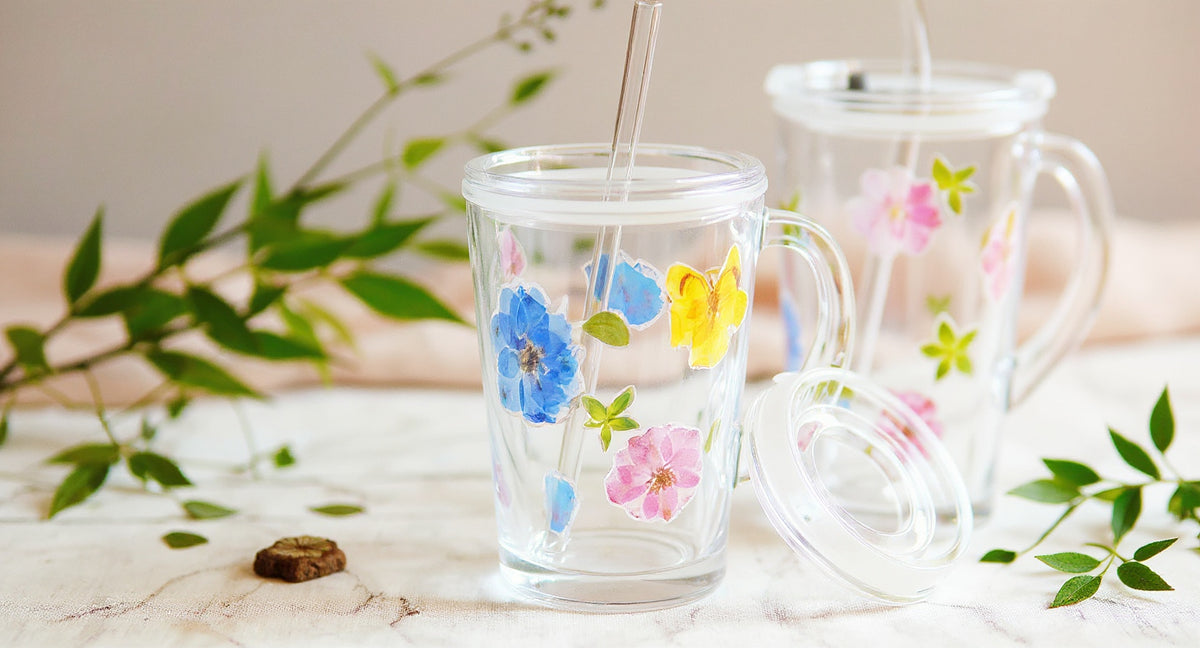 Handcrafted Glass Straw Cup with Real Pressed Flowers 400ml on marble with botanicals